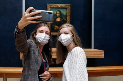 Dos turistas en el Louvre se toman una selfie frente a 