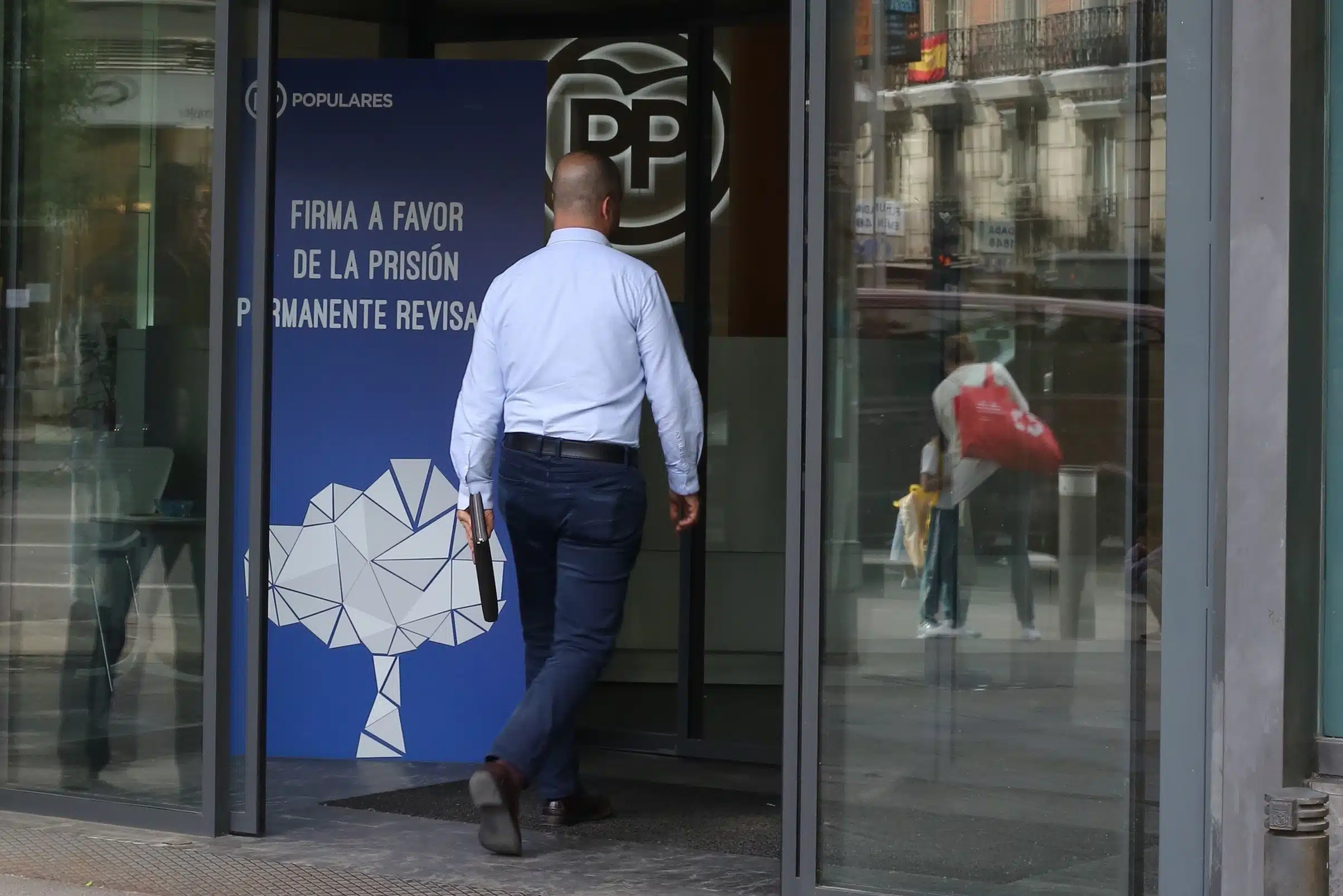 Un hombre entra en la sede nacional del PP por la calle Génova.