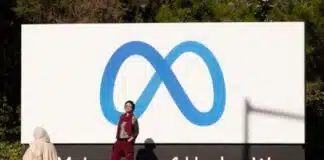 Un hombre posa para una foto frente al cartel de Meta en la entrada de las oficinas de Facebook en California. 
